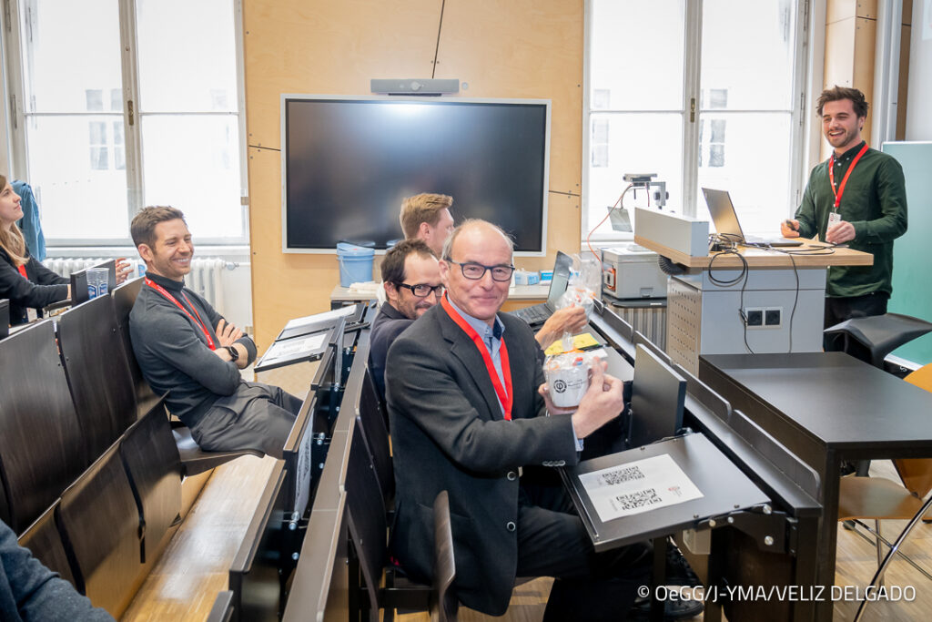 Prof. Helmut Schweiger & Prof. Franz Tschuchnigg bekommen den ersten J-YMA Merch in Form einer J-YMA Kaffeetasse für ihre inhaltliche Unterstützung (Credit: J-YMA)